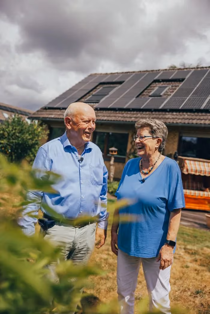 Zufriedenes enercity Kundenpaar vor dem eigenen Haus mit Solaranlage