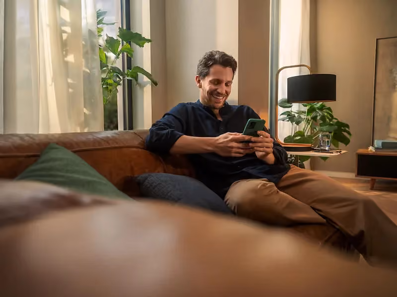 enercity Kunde entspannt mit Smartphone auf dem Sofa